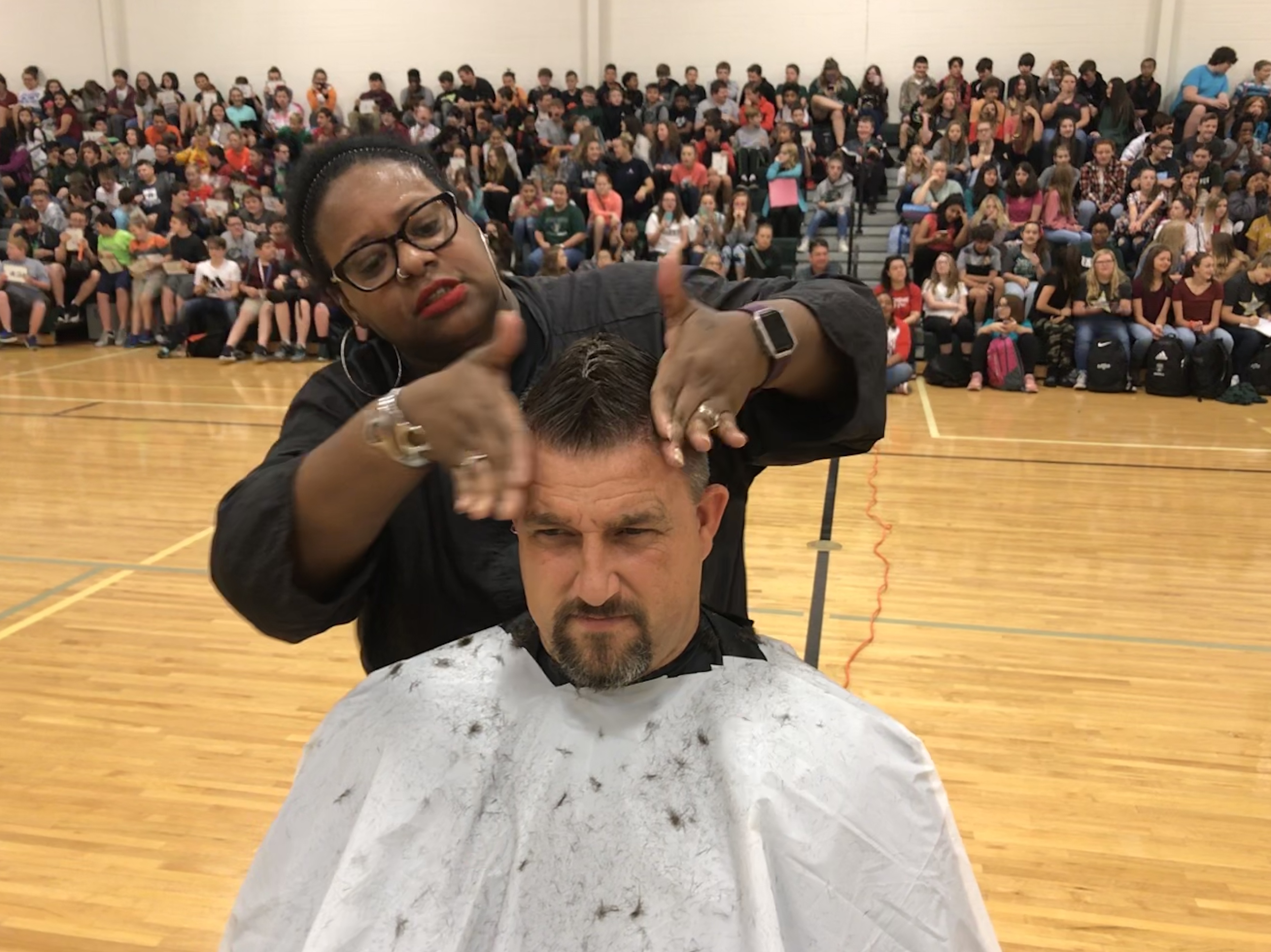April Gardner puts the finishing touches on Carter MIddle School principal Thomas Watson's mohawk.. 